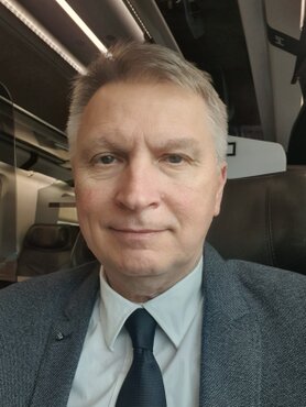 Geometra che mostra dei documenti immobiliari a un cliente seduto alla scrivania