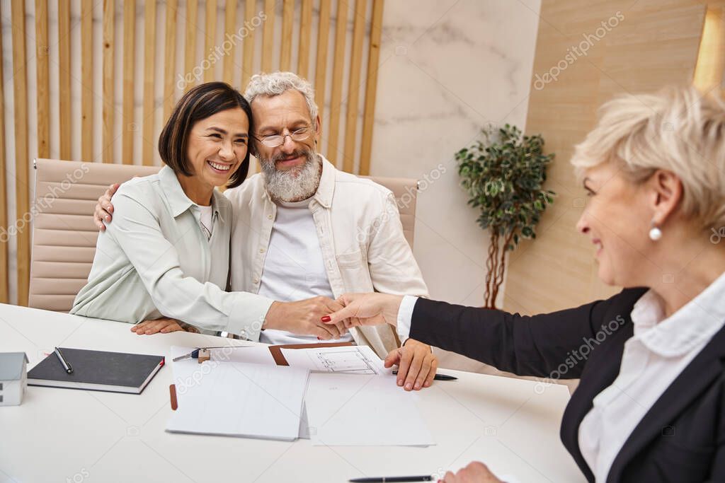 Venditore, acquirente e consulente che si stringono la mano dopo un accordo immobiliare